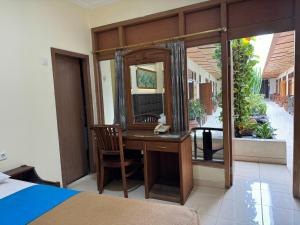 井里汶Hotel Priangan的一间卧室配有书桌和镜子
