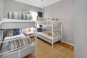 卡拉拉海滩Mar-Lin cute beach house的带三张双层床和一张沙发的房间