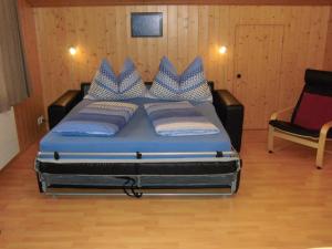 哈斯利伯格Ferienwohnung Nägeliplatten - b48644的一间卧室配有一张带蓝色床单的床和一把椅子