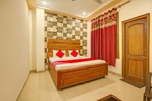 BanūrSuper OYO Hotel NR Residency的一间卧室配有床和红色窗帘