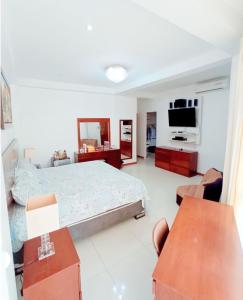 塔拉拉D'eluxe Hotel Talara的一间卧室配有一张床和一台平面电视