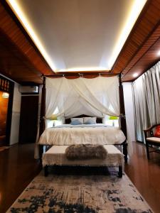 登巴萨Villia magnolia sanur bali 巴厘島玉蘭別墅的一间卧室配有一张带天蓬的床