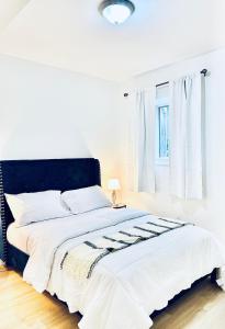 伦敦LaVida Exclusive Guest House (Rm #3)的卧室内的一张带黑色床头板的白色床