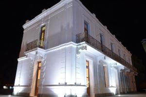罗卡将军市Hotel El Recreo的白色的建筑,晚上有灯