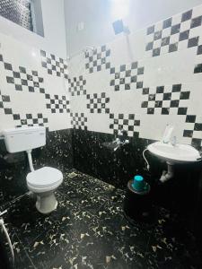 黎明之村Bay Walk Residency的黑白浴室设有卫生间和水槽