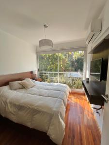 布宜诺斯艾利斯Departamento Premium en Belgrano con Pileta的一间卧室配有一张床、一张书桌和一个大窗户