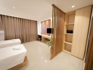 邦劳LEUX Hotel Alona Panglao的配有一张床和一张书桌的酒店客房
