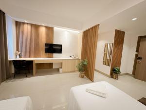 邦劳LEUX Hotel Alona Panglao的酒店客房配有一张床和一张书桌及一台电视
