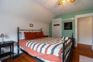 哈利法克斯Charming Townhouse, Historic Hydrostone的一间卧室配有带橙色枕头和绿色墙壁的床。