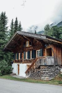 Alphütte bei Lenk und Gstaad的路边带门廊的小木屋