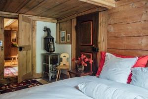 Alphütte bei Lenk und Gstaad的卧室配有一张床铺,位于带木墙的房间内
