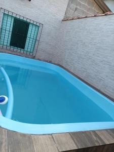 蒙加瓜Casa Praia Mongaguá的大楼旁的蓝色游泳池