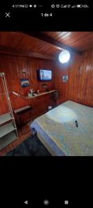 奇廉Alojamiento chillan的卧室配有一张床铺,位于带木墙的房间内