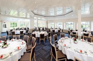 博尔肯豪斯沃德施餐厅酒店的宴会厅配有白色的桌椅
