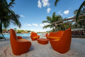 奥兰多Evermore Orlando Resort的一群坐在沙滩上的橙色椅子,靠近一个游泳池