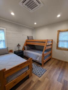 派托普湖畔Cozy Cottage 2BD/2BA, 2 Covered Decks, Patio Dinning, Newly Built!的一间卧室配有两张床和一张双层床。