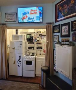 新奥尔良Jazzy Studio in a GREAT Location的一间厨房,配有白色家电和墙上的电视