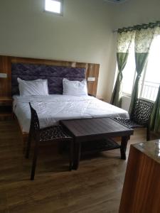 哈里瓦Haridwar and kedarnath dharmshala的一间卧室配有一张床和一张木桌