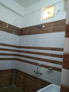 哈里瓦Haridwar and kedarnath dharmshala的墙上有棕色和白色条纹的浴室