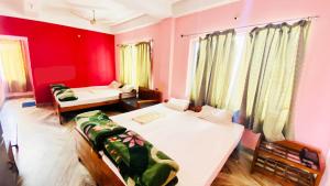 西里古里Hotel Vishal的一间卧室设有两张床和红色的墙壁