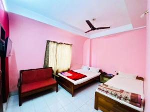 西里古里Hotel Vishal的粉红色的客房配有两张床和椅子