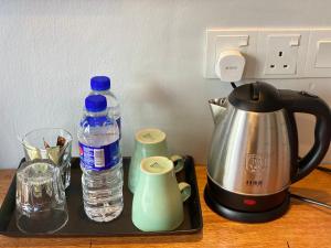 阿罗士打Super 8 Hotel Alor Setar的一个带茶壶和一瓶水的托盘