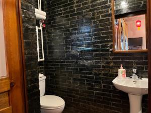 平遥平遥一得客栈的黑色砖浴室设有卫生间和水槽