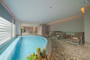 芽庄芽庄哈瓦那酒店的一座配有桌椅的酒店游泳池