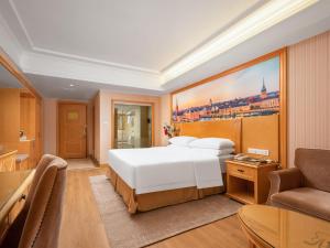 武汉维也纳酒店武汉解放大道店的卧室配有一张白色的大床和一张沙发。