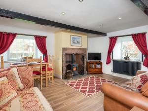 Mawbray2 bed property in Mawbray Cumbria SZ214的带沙发、桌子和壁炉的客厅