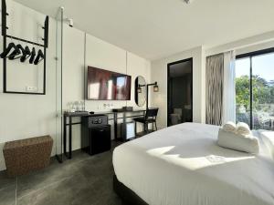 清迈POR Singharat的酒店客房配有一张床、一张书桌和一张书桌。