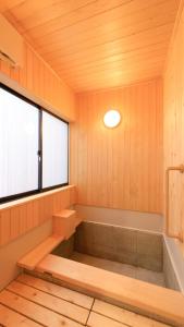 草津草津温泉旅馆的带浴缸的浴室和窗户。