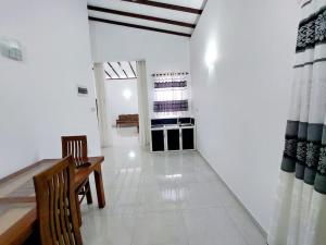 拉夏吉里雅Comfortable Stay in Colombo的客厅配有桌椅,铺有白色地板。