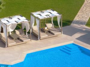 雷夫卡达镇San Giovanni Beach Resort and Suites的享有两个凉亭和游泳池的顶部景致