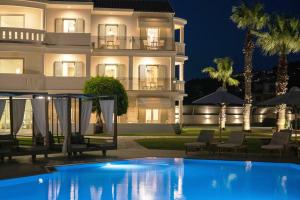 雷夫卡达镇San Giovanni Beach Resort and Suites的夜间带游泳池的别墅