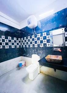 新德里The Nizamuddin palace的一间带卫生间的浴室以及黑色和白色的瓷砖墙。