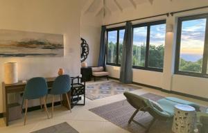 BequiaLux Villa w/ Stunning Panoramic Ocean Views的客厅配有椅子和桌子,设有窗户