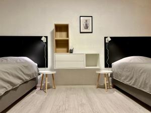 特隆赫姆Simple room的一间卧室设有两张床和两张桌子及架子。