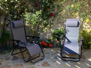 蒙特霍-德拉谢拉Alojamientos El Horno的两把椅子坐在鲜花墙边
