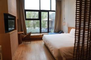 上海上海浦东机场幔麓酒店·宠物友好的一间卧室设有一张床和一个大窗户