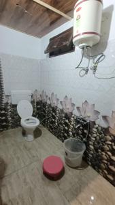 库夫里Chhawani Pro Trek & Camping的一间带卫生间的浴室和鲜花墙