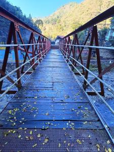 库夫里Chhawani Pro Trek & Camping的一座河上的桥梁,山底下