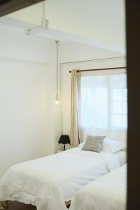 曼谷Private Full-Floor Spacious 5BR in China Town的白色卧室设有两张床,配有窗户