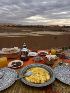 梅尔祖卡骆驼之家住宿加早餐旅馆的上面有盘子的桌子