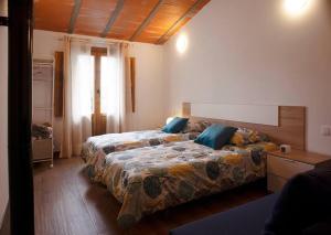 AhínCasa Rural Ana Maria Ain的一间卧室设有两张床和窗户。