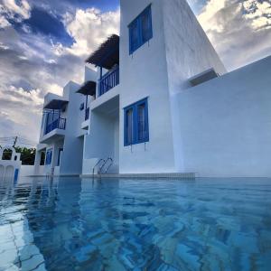 怡保Ipoh Santorini Hideaway - Hotel Inspired的前面有水的白色建筑