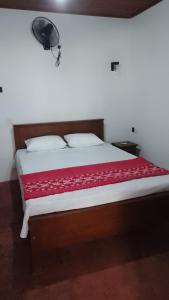 米瑞莎Rainbow mountain villa的一间卧室配有一张带红色毯子的大床