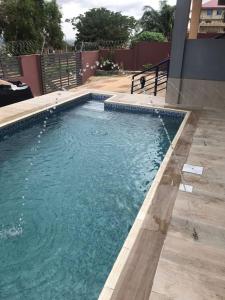 阿克拉Calm Hillside Swimming Pool Villa Apartment的庭院里的一个蓝色海水游泳池