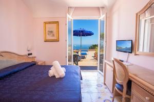 伊斯基亚Hotel Terme Cristallo Palace & Beach的一间卧室配有一张床,享有海景