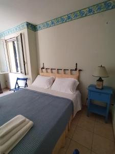 圣卡特琳娜迪纳德appartamento in pineta vista mare的一间卧室配有一张大床和一张蓝色的桌子